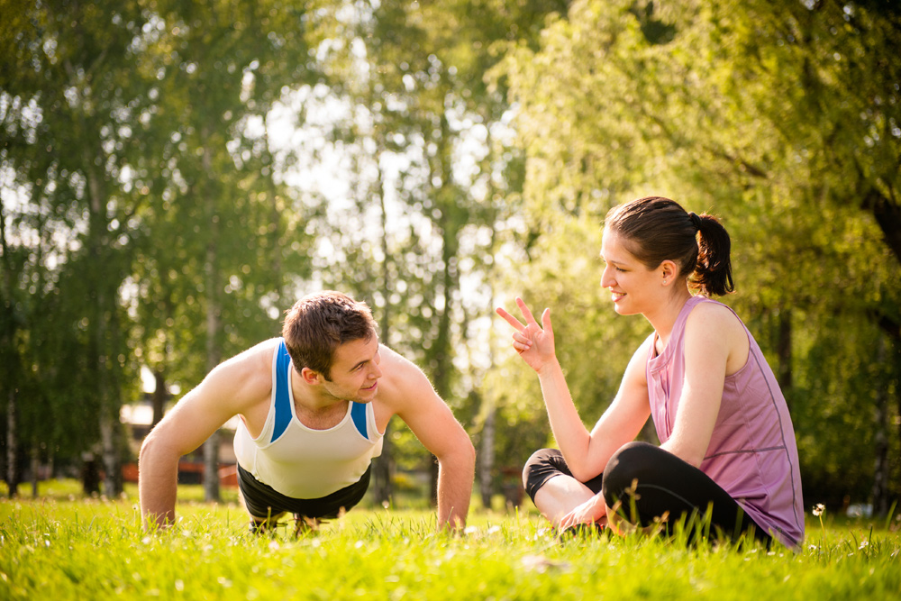 Man doing pushups with woman counting